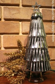 a christmas tree made out of tinsel on a table next to a brick wall