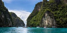 the water is crystal blue and clear with many rocks on both sides that look like mountains