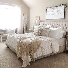 a bedroom with a large bed covered in white blankets and pillows next to a window