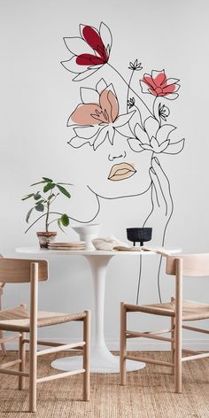 a white table with two chairs next to it and a flower wall decal on the wall