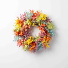 a multicolored wreath on a white wall