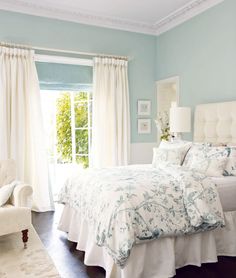 a bedroom with blue walls and white furniture