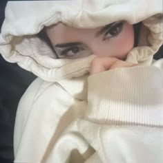 a woman is hiding under a white blanket