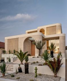 a house with plants and rocks in front of it