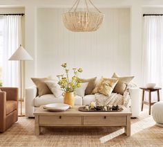 a living room filled with furniture and a chandelier hanging over the top of it