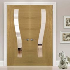 a wooden door with two glass panels on the front and side, in an empty room