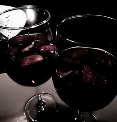 two glasses filled with liquid sitting on top of a table