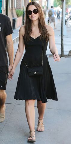 a man and woman walking down the street holding hands