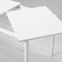 a white table with two triangular shaped tables on it's sides and one in the middle