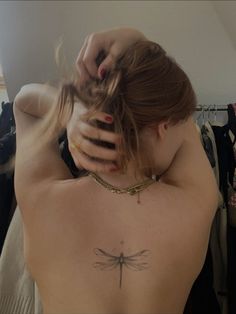 a woman with a dragonfly tattoo on her back