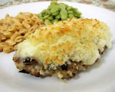 a white plate topped with macaroni and cheese covered meat