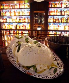 a plate that has some kind of food on it in front of many shelves full of bottles