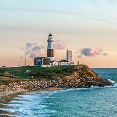 a lighthouse on top of a small island next to the ocean with waves coming in