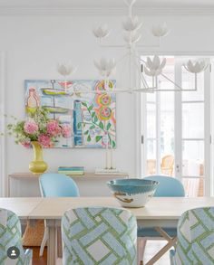 a dining room table with blue chairs and white walls