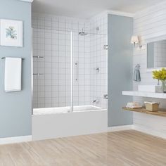 a bathroom with blue walls and white tile on the wall, wood flooring in front of the bathtub