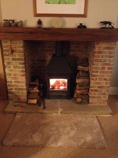 a fire place in the middle of a living room with a rug on the floor