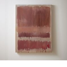 a painting hanging on the wall with white walls and red paint in front of it