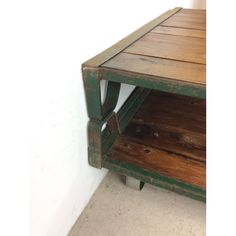 an old wooden table with two shelves on the bottom and one shelf below it that has been painted green