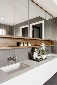 a modern bathroom with two sinks and mirrors