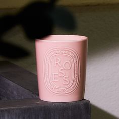 a pink cup sitting on top of a wooden table