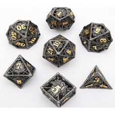 six black and gold metal dices with numbers on the sides, all in different sizes