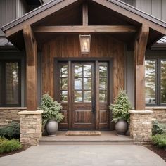 a front door with two planters on each side and an entry way leading into the house