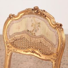 an antique chair with gold paint on it