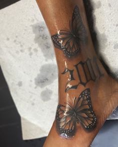 a woman's foot with butterflies on it and the word love written in black ink