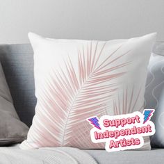 a pillow with the words support independent artists on it and palm leaves in red, white, and blue