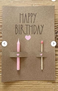 a birthday card with two candles and hearts on the top, one candle is pink