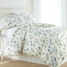 a white bed with blue flowers on it