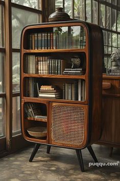 an old fashioned wooden bookcase with many books on it's shelves in front of a window