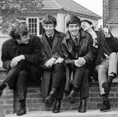 black and white photograph of young men sitting on brick steps