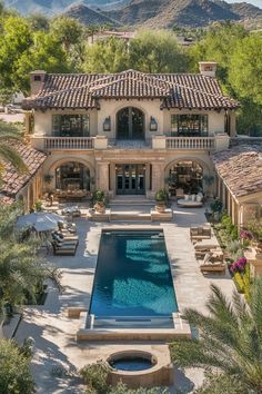 an aerial view of a house with a swimming pool and patio in the foreground