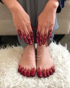 a woman's feet with red nail polish on them