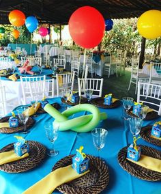 a table set up with plates, napkins and balloons