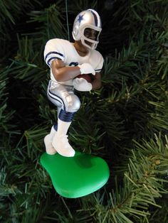 a football player ornament hanging from a christmas tree