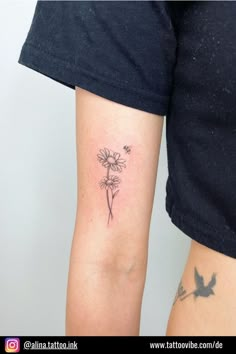 a woman with a tattoo on her arm has a flower and a bird in it