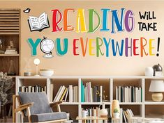 a living room with bookshelves and a large wall decal that says reading will you everywhere