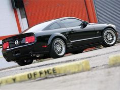 a black sports car parked in front of a building