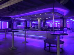 an empty bar with purple lighting in the background