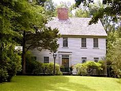 a white house surrounded by trees and bushes