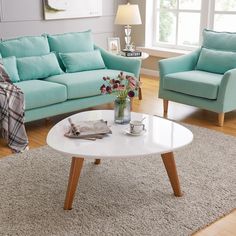 a living room with two blue couches and a white coffee table in the middle