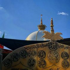 the top of a building with arabic writing on it's roof and dome in the background