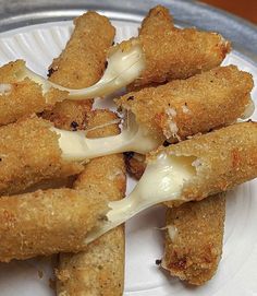 some fried food on a white plate with sauce drizzled over it's edges