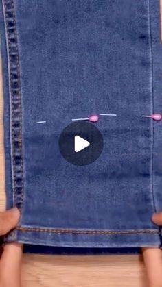 someone is holding up an old pair of jeans to show how they are stitched together