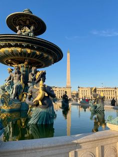 there is a fountain with statues around it