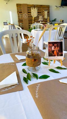 a vase filled with flowers sitting on top of a table covered in white linens