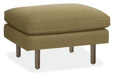 a small footstool with wooden legs and a green fabric cover on the top