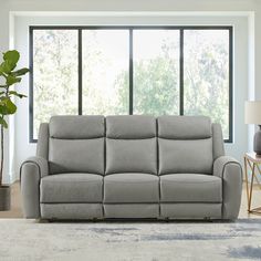 a living room scene with focus on the reclining sofa and large window in the background